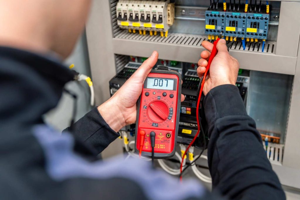 électricien qui effectue un dépannage électrique sur un tableau électrique a Grenoble
