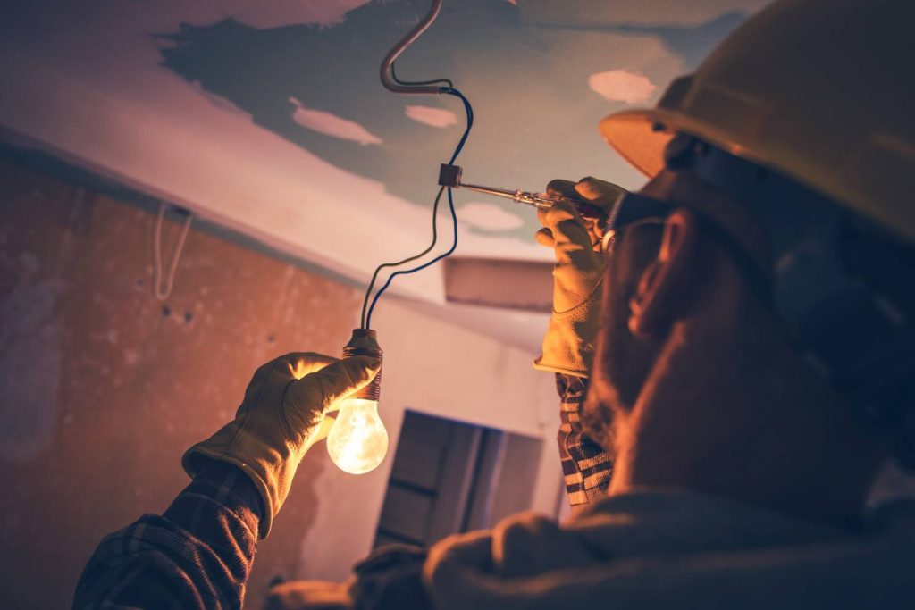 électricien a Grenoble qui installe une ampoule