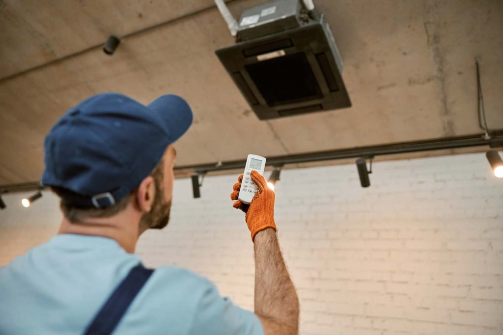 électricien qui installe une climatisation dans un commerce à Grenoble
